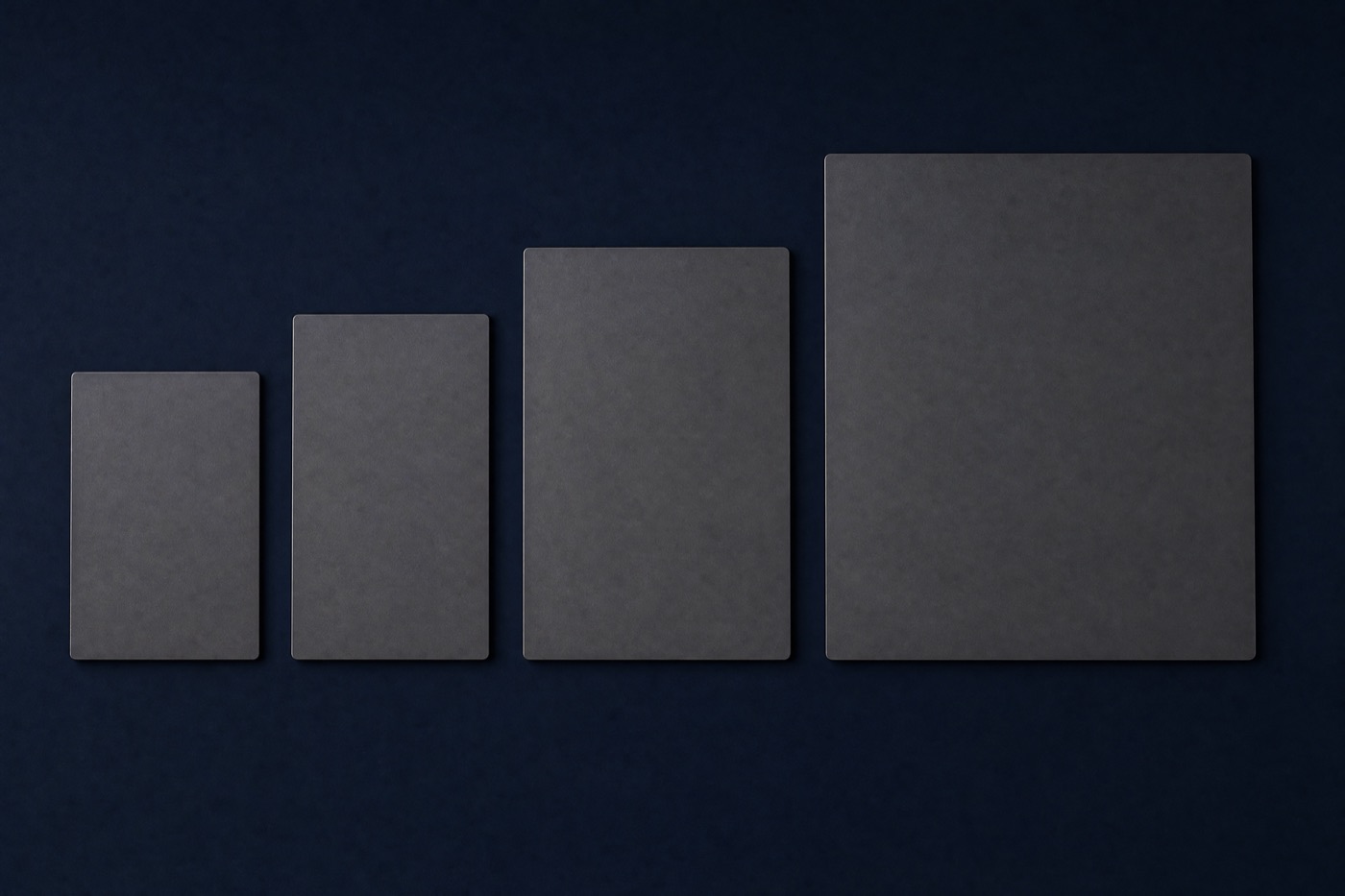 Four blank matte grey slabs in ascending sizes laid in a row